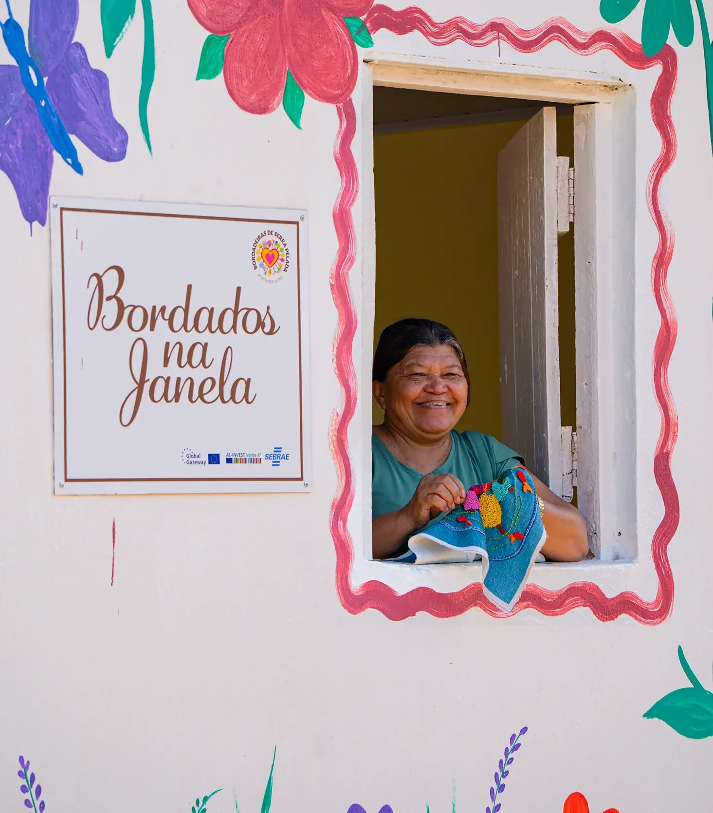Bordadeira de Serra Pelada mostrando seu trabalho na janela